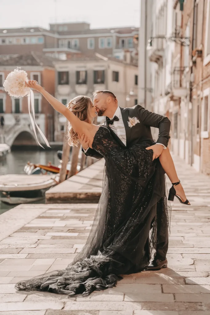 Ein Brautpaar in einer romantischen Kuss-Pose am malerischen Kanal von Venedig – Hochzeitsfotograf Venedig.