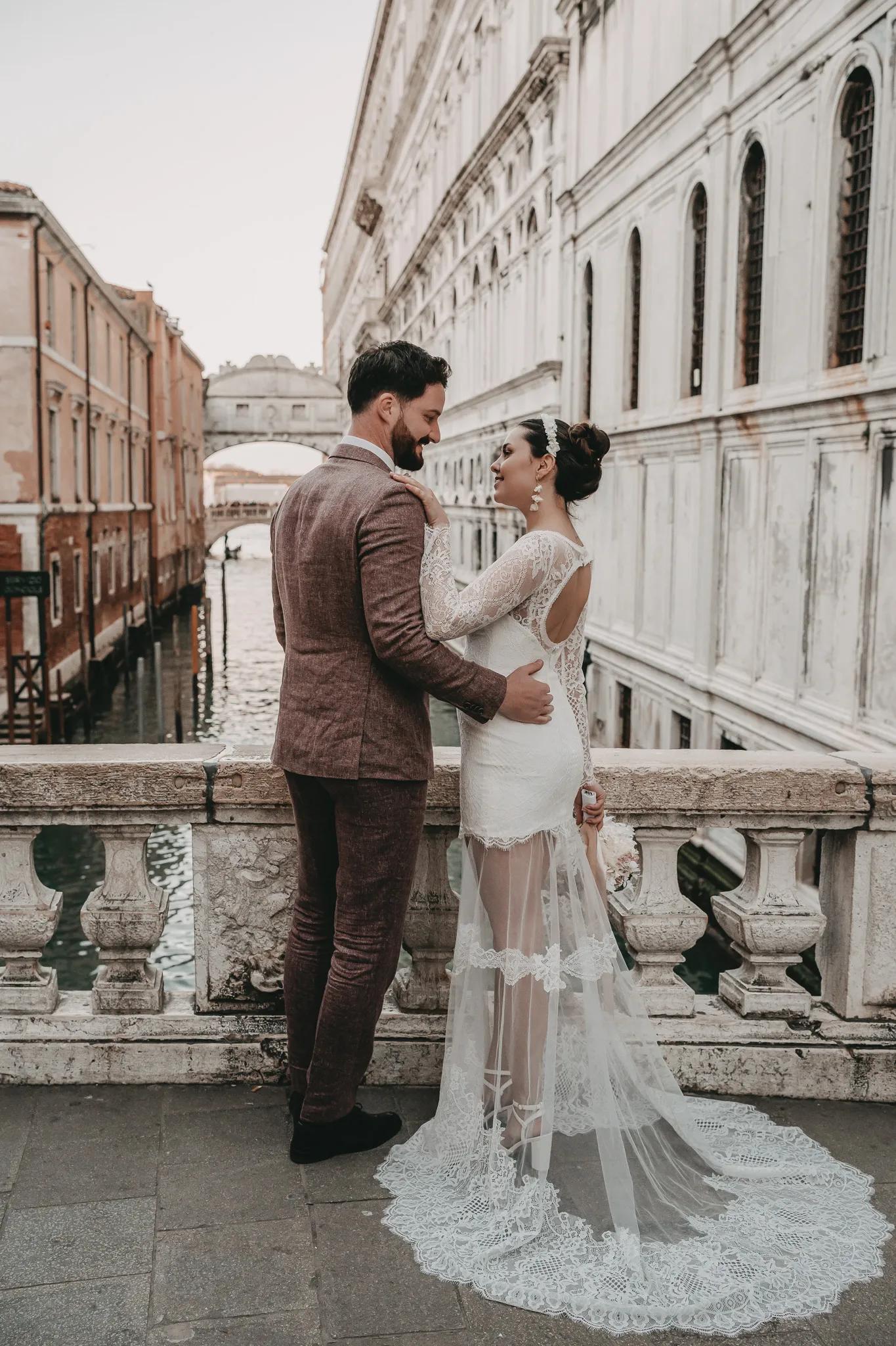 Brautpaar vor der berühmten Seufzerbrücke in Venedig, ein romantisches Motiv für unvergessliche Hochzeitsfotos.