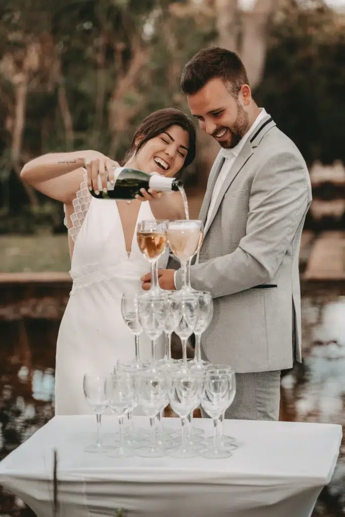 Braut gießt Champagne in Champagnerturm